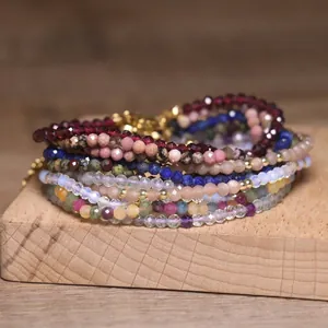 Close-up of stacked colorful natural gemstone beaded bracelets with faceted tourmaline
