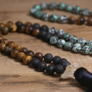 Collar artesanal de cuentas con borla de ojo de tigre y piedras de lava naturales.