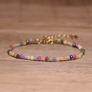 Close-up detail of a colorful natural tourmaline faceted bead bracelet with gold clasp
