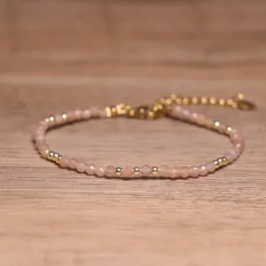 Close-up detail of handmade beaded bracelet featuring faceted natural pink stone beads