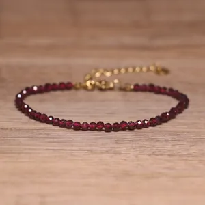 Detailed view of faceted red natural stone bead bracelet with elegant gold extender chain