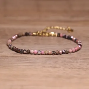 Macro detail of a handmade multi-color natural stone beaded bracelet with gold chain