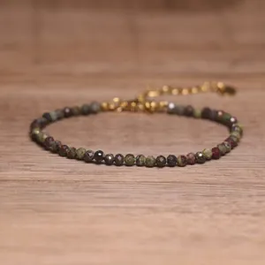 Macro view of a delicate natural tourmaline bracelet with faceted beads on a wooden surface