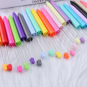 Fila de bolígrafos de cuentas de colores con varillas largas de metal en fondo blanco.