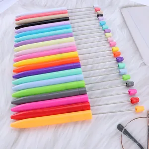 Variedad de bolígrafos largos de colores para cuentas sobre fondo de piel sintética.