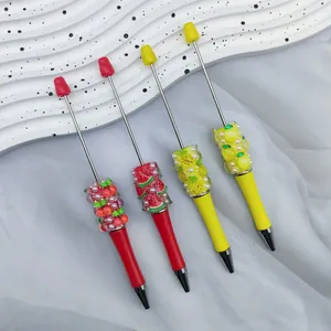 Detailopname van creatieve DIY fruitparelpennen met kleurrijke strassteentjes en parels