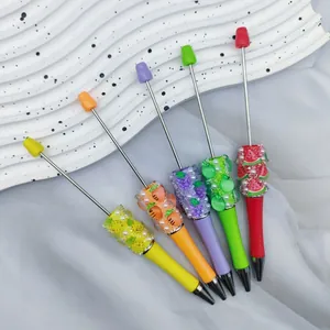 Gedetailleerd zicht op kleurrijke DIY-parelpennen met fruitmotieven en kristallen
