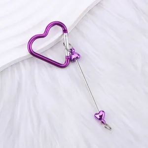 Metallic purple heart-shaped carabiner keychain with heart beads on white fur background