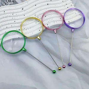 Set of four colorful electroplated 3x magnifying glasses on white wavy decorative props