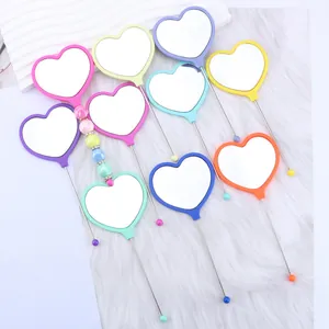 Colorful heart-shaped portable hand mirrors with decorative beaded handles for girls.