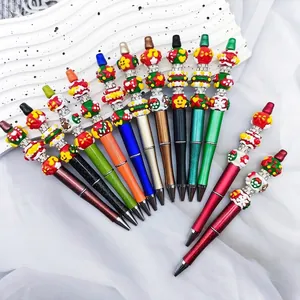 Close-up of colorful Christmas themed beaded ballpoint pens featuring festive charms