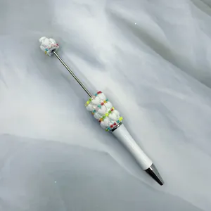 Elegant handmade DIY heart beaded pen featuring macaron candy colors on white fabric