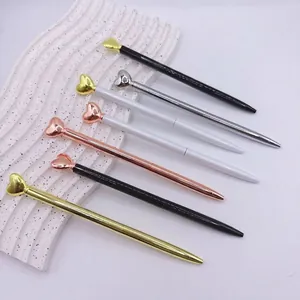Elegant heart-topped metal ballpoint pens in multiple metallic colors for business gifts.