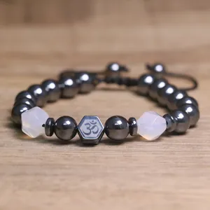 Detailopname van hematiet kralenarmband met Om-symbool en gefacetteerde kralen