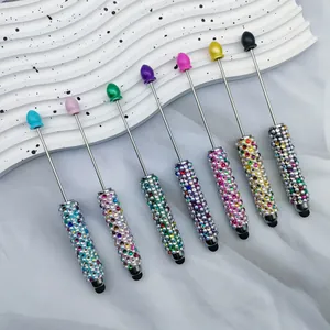 Detail shot of seven colorful rhinestone-beaded touchscreen stylus pens on a white tray
