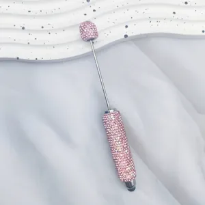 Close-up of pink rhinestone-encrusted dual-purpose stylus pen on white background