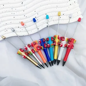 Colorful Christmas themed DIY beaded ballpoint pens featuring festive decorations