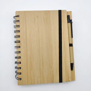 Close-up view of eco-friendly bamboo spiral notebook with matching pen and elastic closure