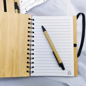 Detail view of eco-friendly bamboo spiral notebook with lined paper and matching pen.