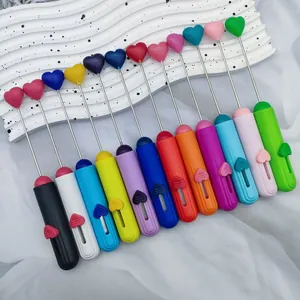 Dettaglio di vari coltelli artigianali colorati con perline a forma di cuore DIY