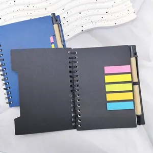 Detail view of spiral notebook with colorful sticky notes and pen on white fabric.
