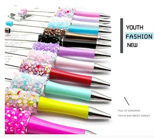 Close-up detail showing colorful sequin and bead patterns on DIY ballpoint pens