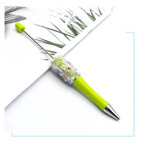 Macro detail of lime green DIY beaded ballpoint pen with colorful sequin decorations