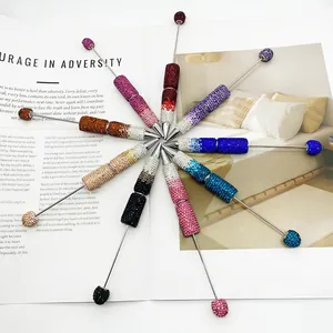 Vue détaillée de douze stylos à bille colorés avec perles de cristal dégradées