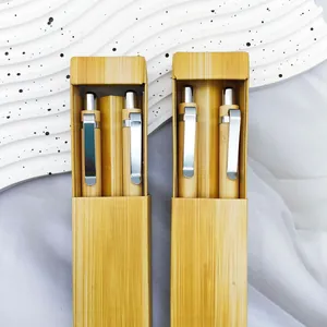 Detalle de dos juegos de bolígrafos de bambú vintage en cajas de regalo de madera