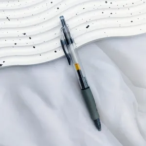 Macro view of a 0.5mm retractable black gel pen with transparent barrel and green grip