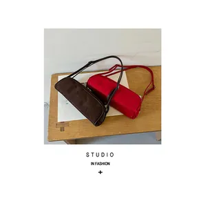 Detailed view of stylish brown suede and red leather underarm bowling baguette bags