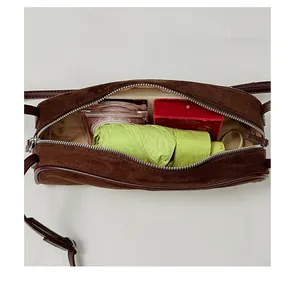 Interior view of brown suede bowling bag showing storage capacity for umbrella and makeup.