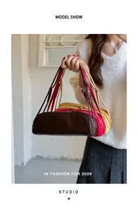 Detail shot of three stylish bowling bags in brown, red, and yellow held by a model.