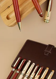 Detailed view of assorted wooden business ballpoint pens on a brown leather notebook