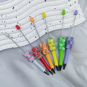 Detailweergave van kleurrijke kraalbare pennen met fruitmotieven en strass