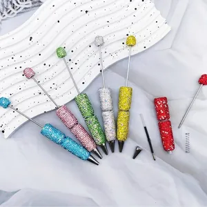 Detailed macro view of colorful rhinestone beaded pens showing internal refill components.
