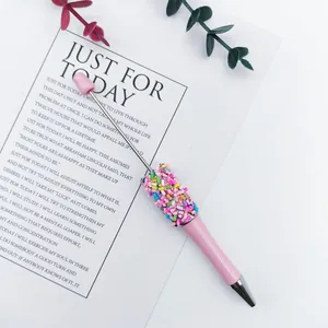 Macro view of a pink beaded ballpoint pen featuring colorful rainbow sprinkle beads