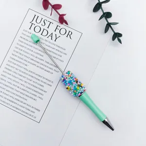 Detail view of a mint green ballpoint pen decorated with candy sprinkle beads