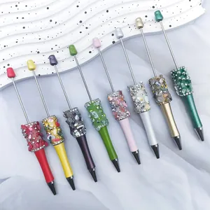 Detailed view of colorful DIY beaded ballpoint pens with decorative crystal stones.