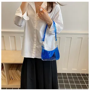 Model met een trendy blauwe transparante PVC-okseltas en een stijlvol wit overhemd