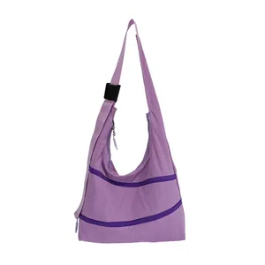 Detail of purple shoulder bag featuring multiple zipper compartments and an adjustable strap