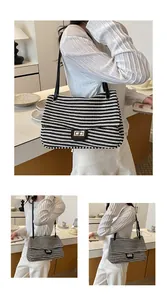 Elegante bolso de hombro tejido a rayas blancas y negras llevado por una modelo