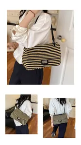 Vista detallada de un bolso grande de paja tejida con diseño de rayas negras y beige