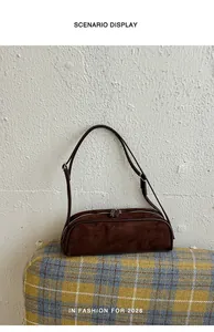 Detailed view of a brown suede bowling-style baguette underarm shoulder bag for women.