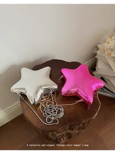 Due borse da sera metalliche a forma di stella argento e rosa su un supporto di legno