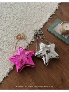 Eleganti borse da sera metallizzate a forma di stella in argento e rosa su pavimento