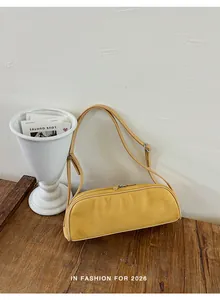 Detailed view of the yellow suede-textured baguette bag on a wooden table setting.