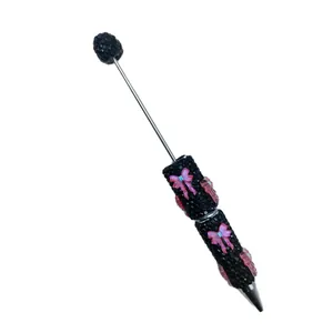 Elegant DIY beaded pen featuring black rhinestones and pink butterfly bow decorations.