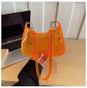 Detailweergave van een feloranje transparante PVC-okseltas met zilveren hardware