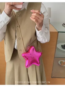 Dettaglio di una borsa da sera alla moda in acrilico lucido a forma di stella rosa con catenina